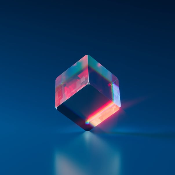 a glassy-looking quadrangular prism reflecting light, forming a reddish color effect on its body.